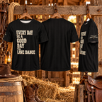 Three black line dancing jerseys on wooden hangers in a rustic stable showing front design, plain back and More Than Just Steps sleeve print