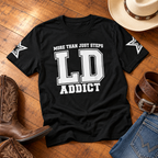 Black LD Addict line dancing T-shirt flat lay with cowboy boots, hat, belt and jeans