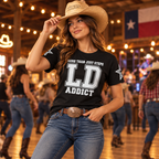 Woman wearing the black LD Addict line dancing T-shirt with sleeve star graphics at a country dance venue