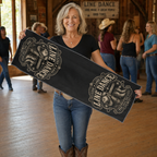 Mature line dancer holding the black Live Love Line Dance 30 by 90 centimetre quick-dry towel