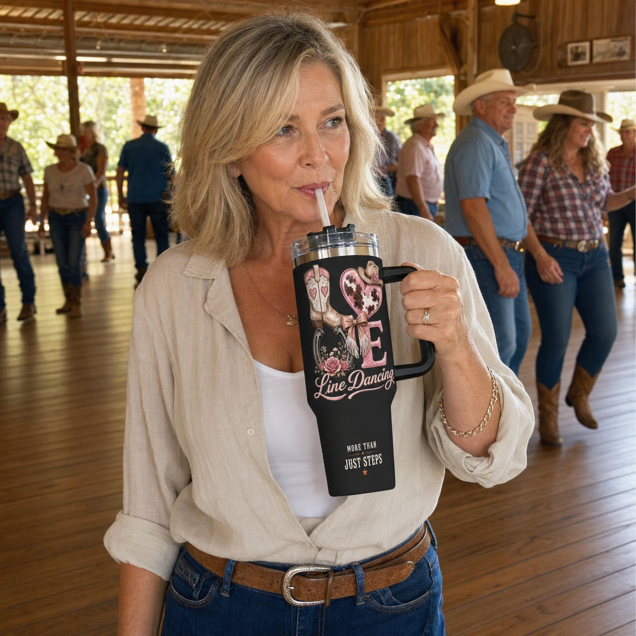 Mature line dancer drinking from LOVE Line Dancing 40 oz tumbler at a country dance hall