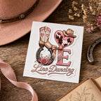 Pink LOVE Line Dancing sticker on its backing beside a cowgirl hat, horseshoe, ribbon and dried flowers