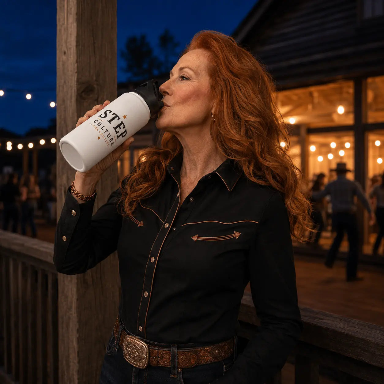 Line dancer drinking from the Step Culture Collective Signature personalised stainless steel bottle at an evening dance venue
