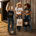 Lifestyle image of a cotton tote bag featuring a longhorn skull surrounded by western flowers.