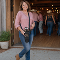 Mature woman wearing the black western cowgirl tumbler carrier crossbody with matching cup